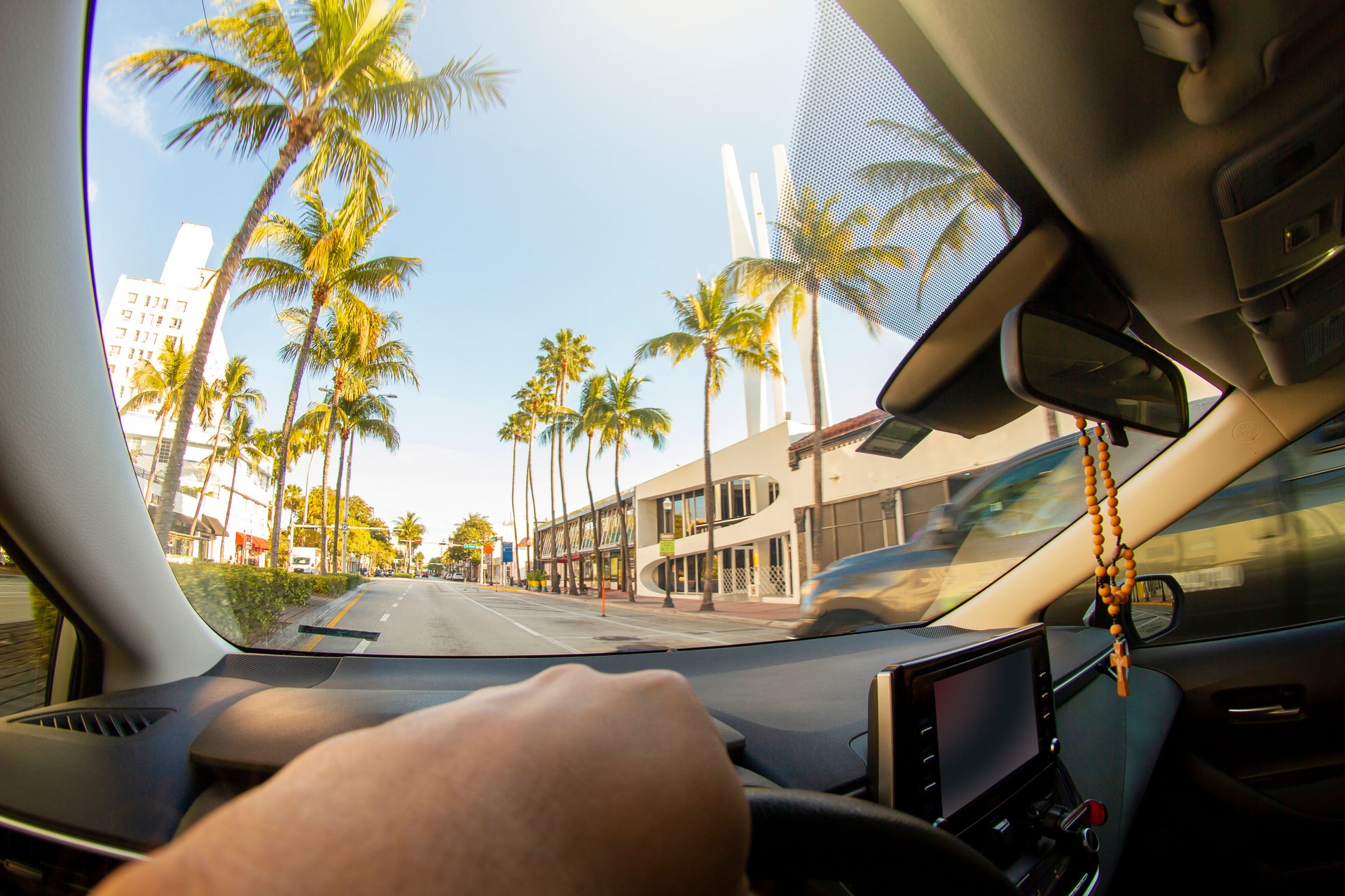 POV Point of view shot of a young sport man driving a car in front of a paradise blue sea landscape at Miami Beach District Area, Miami, South Florida, United States of America - USA